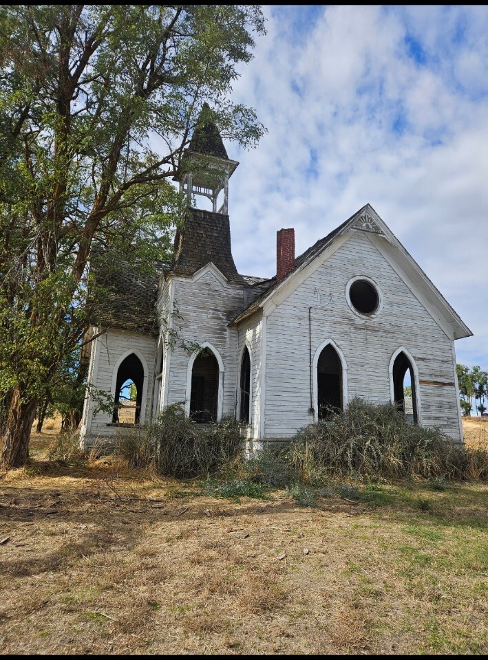 Weathered historic church in Grass Valley beneath a cloudy sky