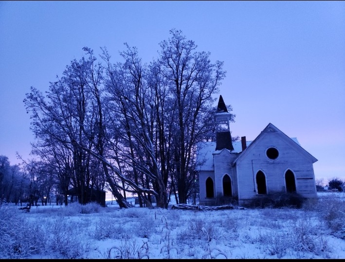 Historic Grass Valley church in winter snow and blue twilight